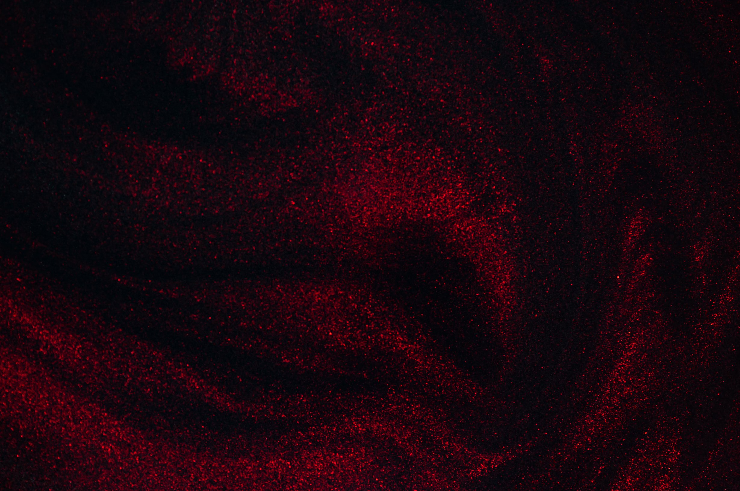 Abstract glitterd painted black with red background.